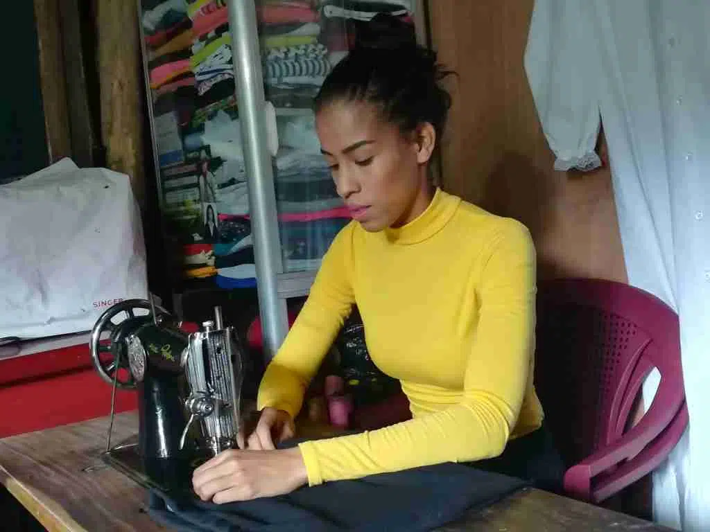 Grayling sewing a black cloth on sewing machine