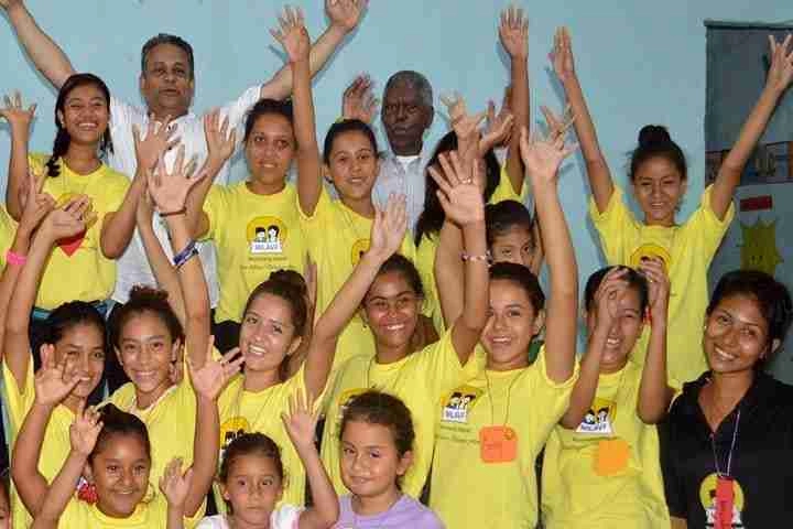 Patrick Canagasingham and Digema with national girl's group who are raising their hands up in the air