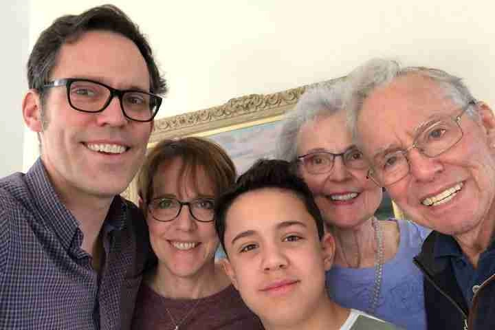 two grandparents, two parents and their child in a family photo