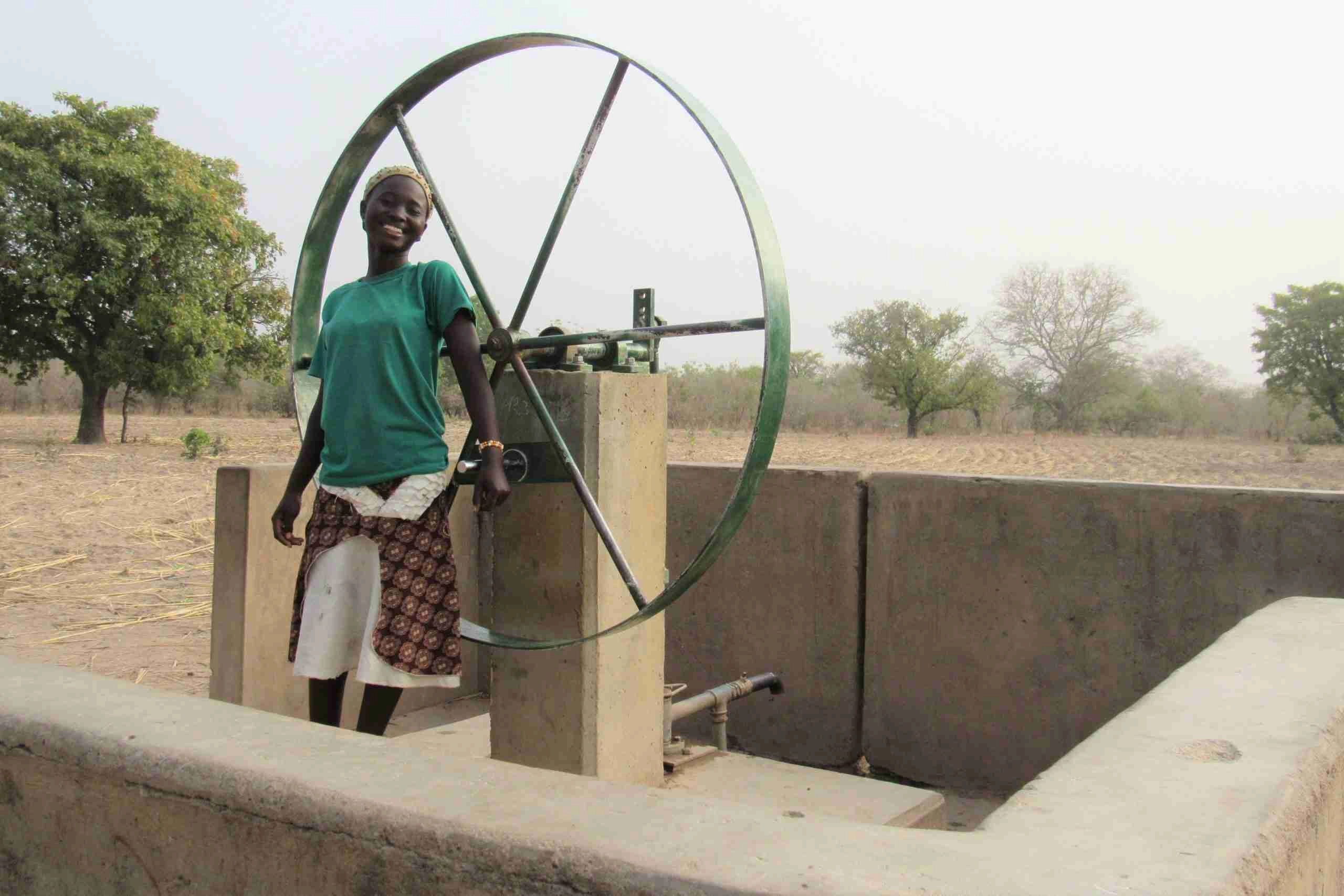 Nana standing bestide a water pump station