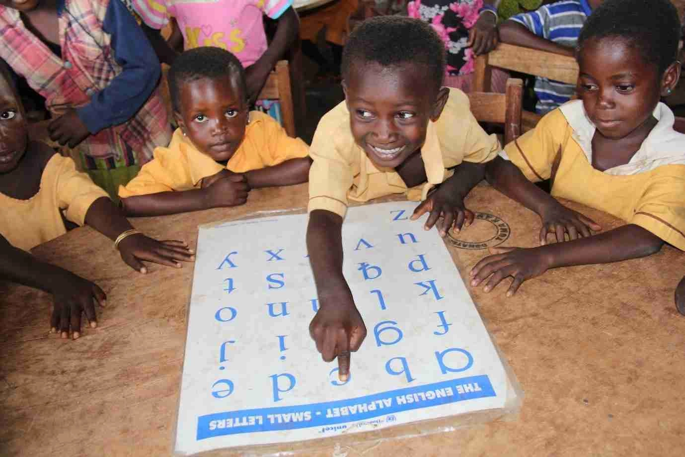 One of the kids in Ghana point to letter C on alphabet chart 